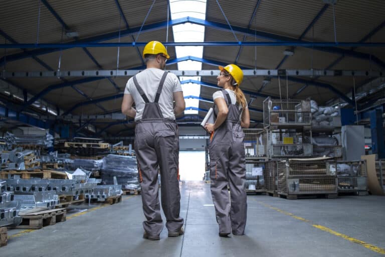 Produktionsmitarbeitende besprechen einen Ablauf in der Fertigungshalle